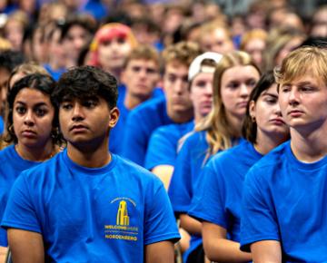 Students sitting wearing matching blue shirts