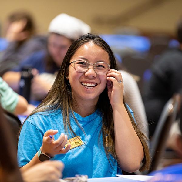 Student with glasses laughing.