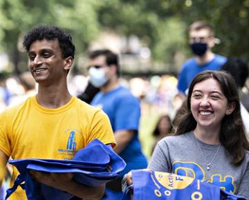 Students on campus carrying blue bags.