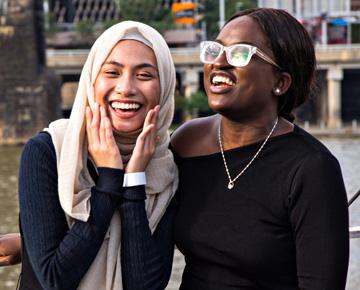 Two students smiling outside.