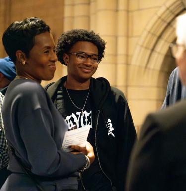 A mother and son smiling in conversation.